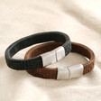 Men's Wide Woven Leather Bracelet in Black next to brown version on top of beige coloured fabric