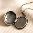 Antiqued Crystal Star Oval Locket Necklace in Gold open on top of beige coloured fabric