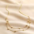Full photo of Double Chain and Star Charm Necklace in Gold on Beige Fabric