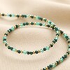 Gold Stainless Steel Stone Bead Necklace in Green arranged on top of neutral coloured fabric