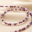 Gold Stainless Steel Stone Bead Necklace in Purple laid on top of beige coloured fabric