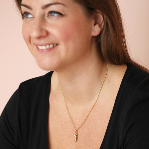 Necklace on Model Model smiling wearing Labradorite Crystal Point Pendant Necklace in Gold against pink background