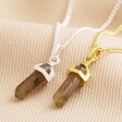 Labradorite Crystal Point Pendant Necklace in Silver on top of beige fabric with gold version