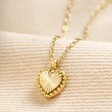 Stainless Steel Tiny Heart Pendant Necklace in Gold on Beige Fabric