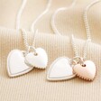 Textured Double Heart Necklace in Silver With Textured Double Heart Necklace in Rose Gold on Beige Fabric