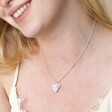 Close up of Textured Double Heart Necklace in Silver on Smiling Model