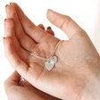 Textured Double Heart Necklace in Silver Held in Model's Hands