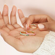 Model Holding Set of 3 Enamel and Crystal Stacking Rings in Gold in Palm