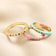 Set of 3 Enamel and Crystal Stacking Rings in Gold On Beige Fabric