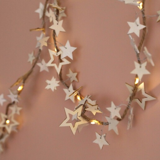 Battery Powered LED Wooden Star Garland hung up on wall against natural coloured background
