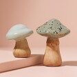Small Ceramic Toadstool Ornament on top of raised surface next to large size with pink background