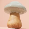 Small Ceramic Toadstool Ornament from underneath against pink backdrop