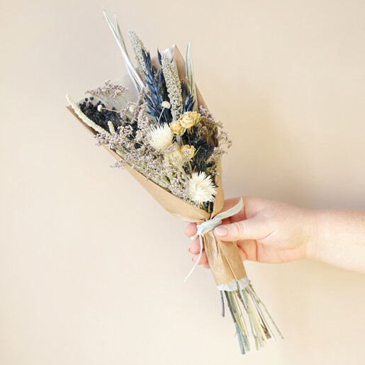 Midwinter Dried Flower Posy Held By Model Against Beige Wall