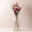 Mulled Wine Dried Flower Bouquet  in Vase On Beige Surface 
