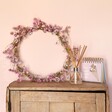Pink Ixodia Daisy Dried Flower Wreath Making Kit	made up and sat on top of wooden counter with reed diffuser and flip chart