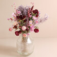 Summer Nights Dried Flower Bouquet in round glass vase against pink background