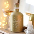 Personalised 700ml Gold Starry Gin in lifestyle shot on wooden counter in front of mirror with cocktail behind