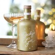 Personalised 700ml Gold Starry Gin in lifestyle shot in front of mirror with cocktail behind
