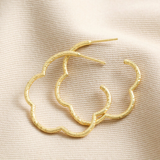 My Doris Etched Flower Hoop Earrings in Gold stacked on neutral coloured material
