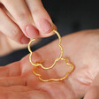 Model holding My Doris Etched Flower Hoop Earrings in Gold in palm of hand
