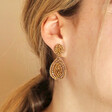 Close up of My Doris Gold Beaded Teardrop Drop Earrings on model