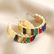 My Doris Large Rainbow Hoop Earrings in Gold on neutral coloured fabric