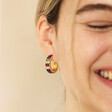 Model laughing wearing My Doris Medium Rainbow Hoop Earrings in Gold