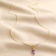 Full length Amethyst Crystal Point Pendant Necklace in Gold on beige fabric