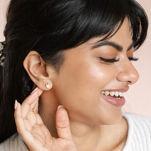 Brunette model wearing Festive Crystal Reindeer Stud Earrings in Gold