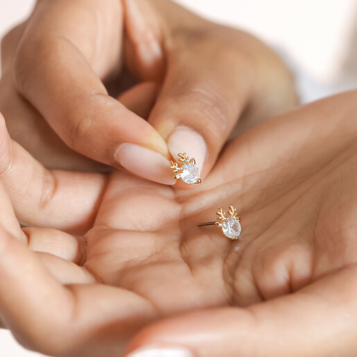 Model holding the Festive Crystal Reindeer Stud Earrings in Gold in palm