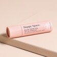 Packaging for the Aery Happy Space Rose Geranium Amber Pulse Point Roll On - on a neutral background