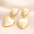 A pair of gold plated earrings with butterfly backs. The hearts are 3D and lightweight. The smaller heart is attached to the larger heart by a chain link