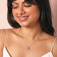 Sunbeam Heart Pendant Necklace in Gold on model smiling against beige coloured backdrop