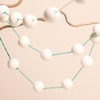 Afroart Felt Balls Garland in White and Green on a beige background