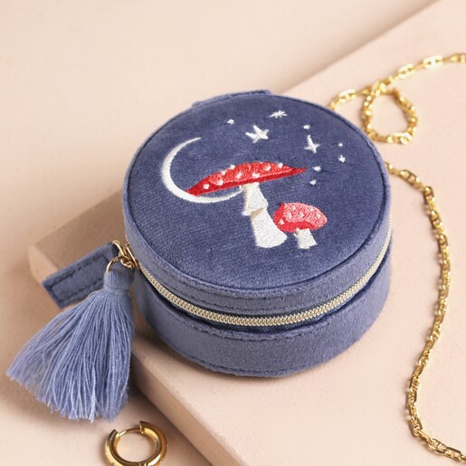 Moonrise Mini Round Velvet Travel Jewellery Case in Blue on Neutral Background Dusky Blue Velvet Circular Jewellery Case With a Toadstool and Star Embroidered Emblem on a Neutral Surface