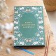 Green Floral Daily Gratitude Journal on a wooden theme background