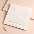 Personalised wedding guest book with custom gold cursive font on a beige background