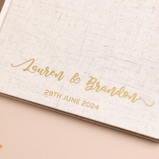 Close up of personalised wedding guest book with custom gold cursive font 