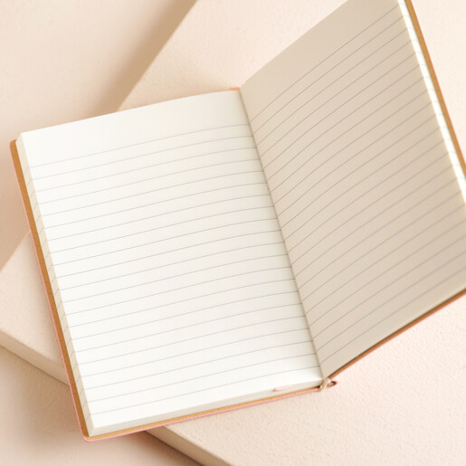 Pink Vegan Leather Embossed Notebook Opened on Beige Background