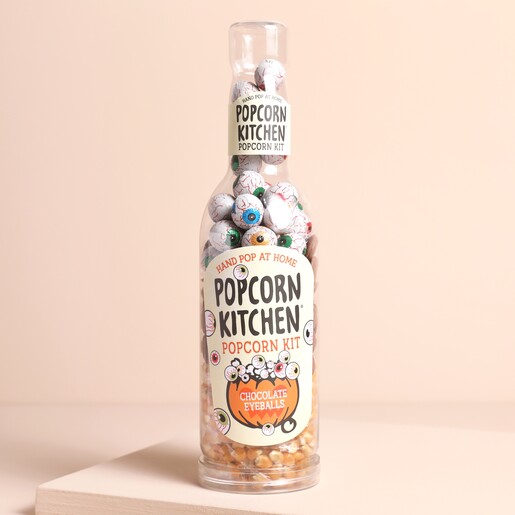 Popcorn Kitchen Chocolate Eyeballs Gift Bottle on a beige background, full of popcorn kernels, chocolate buttons and eyeball foil covered chocolate balls