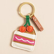 Caroline Gardner Cake Slice Keyring on a Beige Background