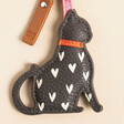 Caroline Gardner Black Cat Heart Keyring with White Hearts, Red Collar and Pink Strap on a Beige Background