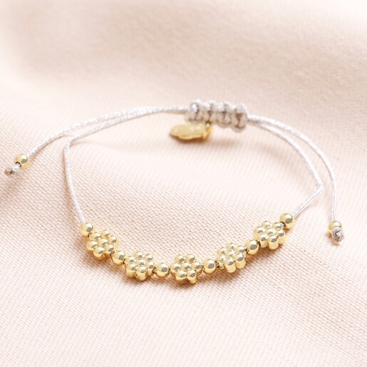 Estella Bartlett Flower Chain Friendship Bracelet on Beige backgounf