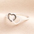 A Slim Band Silver Ring With Heart Details on Neutral Fabric