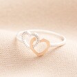 A Slim Band Sterling Silver Ring With Heart Details on Neutral Fabric