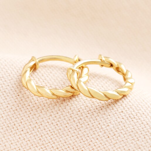 Close Up of Hoops Rope Huggie Earrings in Gold on Beige Background