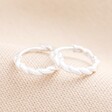 Sterling Silver Rope Huggie Hoop Earrings on Beige Background