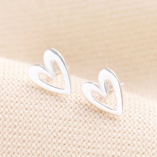 Sterling Silver Heart Outline Stud Earrings in Silver on a Beige Background.  A pair of chunky outline heart earrings with butterfly backs in sterling silver.
