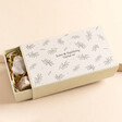 Image of the box open slightly, showing the front leaf print pattern and wording, along with crystals inside