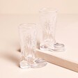 Set of 2 empty Cowboy Boot Shot Glasses on a neutral background